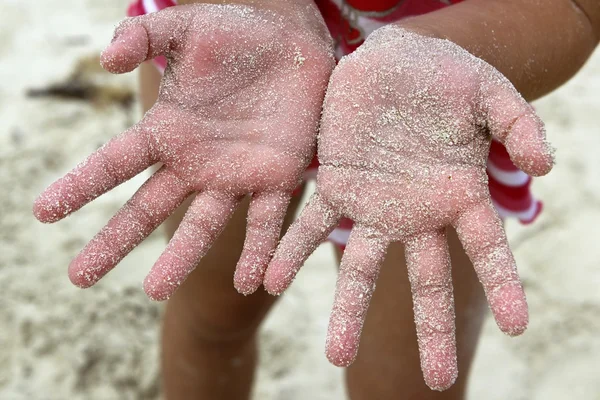 Děti dívka písek z pláže ruce čelí fotoaparát — Stock fotografie