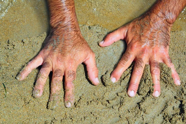 Peludo homem mãos na areia da praia no verão ensolarado — Fotografia de Stock