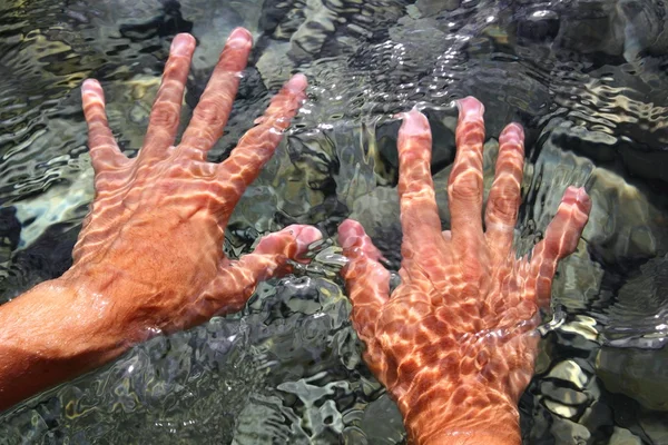 Mãos debaixo de água do rio formas onduladas — Fotografia de Stock