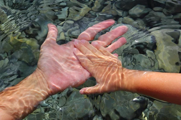 Felnőtt és gyermek kezében tartja a víz alatti — Stock Fotó