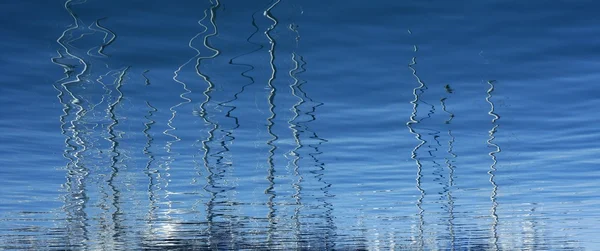 Boats abstract reflexion over blue water — Stock Photo, Image