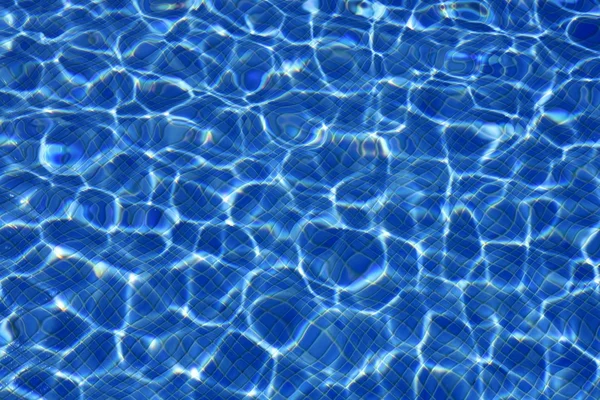 Blauwe water textuur, tegels zwembad in zonnige dag — Stockfoto