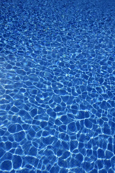 Blauwe water textuur, tegels zwembad in zonnige dag — Stockfoto