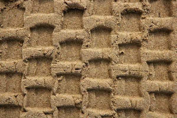 Textura de arena de playa con huella de neumáticos de vehículo —  Fotos de Stock