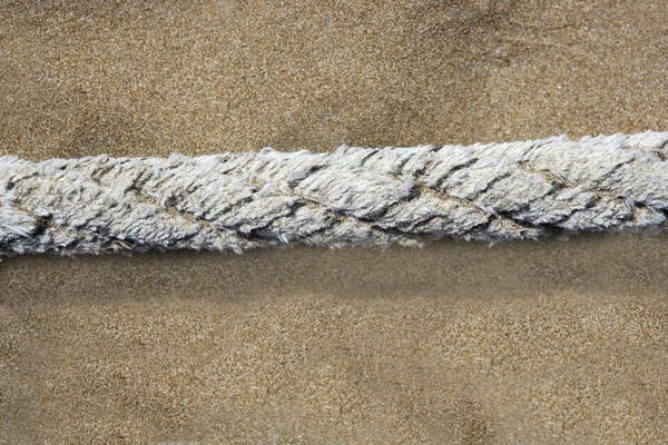 浜の砂の背景の上の高齢船舶用ロープ — ストック写真