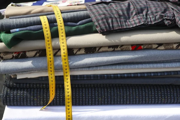 Textiles fabrick apilados cinta métrica amarilla —  Fotos de Stock