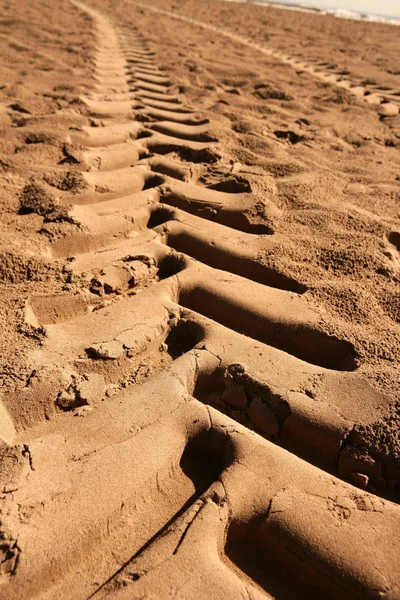 Fußabdruck von Industrietraktoren auf Sand am Strand — Stockfoto