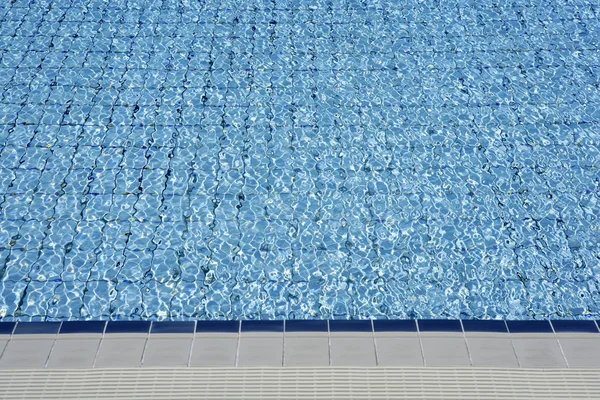 Azulejos azules piscina olas de agua perspectiva — Foto de Stock