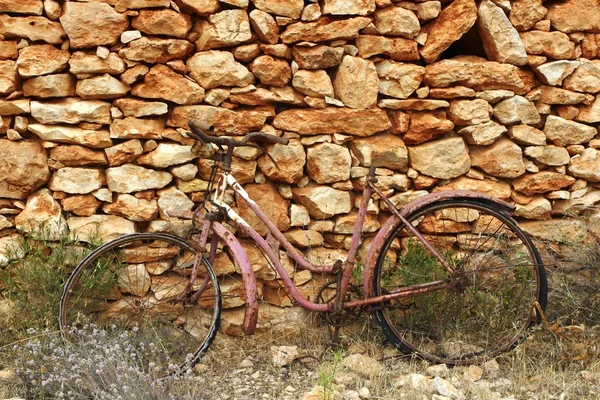 老年风化的自行车复古石头砌的墙 — 图库照片