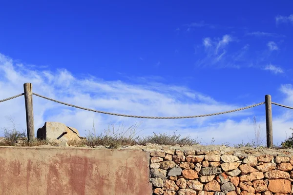 Recinzione tradizionale corda sopra grunge muro di pietra — Foto Stock