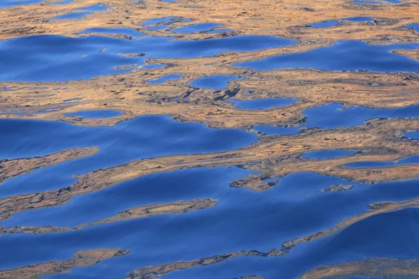 Abstrakte goldene Reflexion blaue Wasserformen — Stockfoto