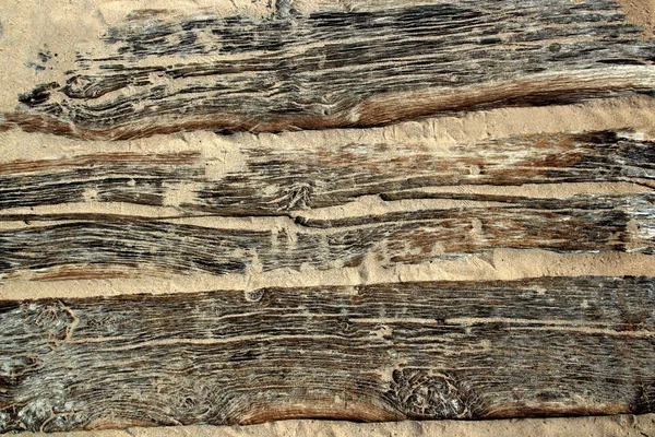 Texturu dřeva ve věku pláž s pískem zvětralé — Stock fotografie