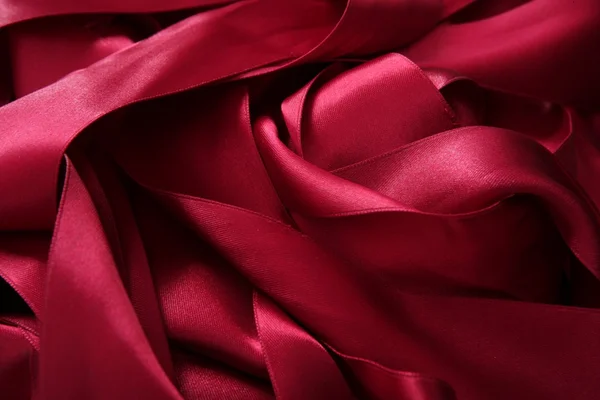 Red satin ribbons in a messy mess texture — Stock Photo, Image