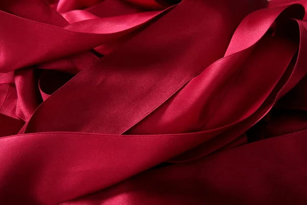 Κόκκινο σατέν κορδέλες σε ένα ακατάστατο χάος υφή — Φωτογραφία Αρχείου