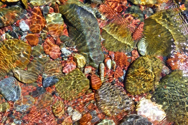 Rivier water onder stroom rode rotsen transparantie — Stockfoto