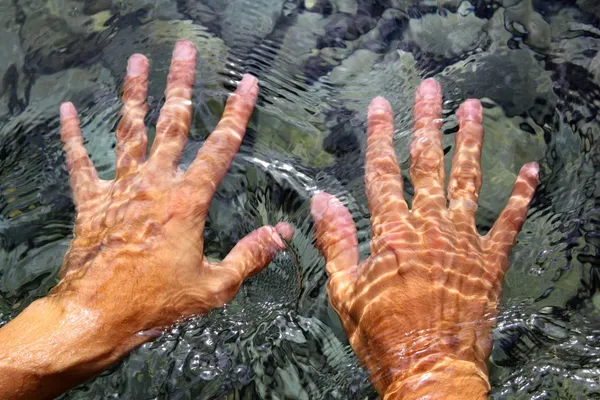 Ruce pod vodou říční vody vlnité tvary — Stock fotografie