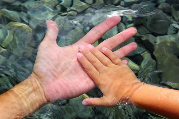 Ενηλίκων και παιδιών χέρια που κρατούν υποβρύχια — Φωτογραφία Αρχείου