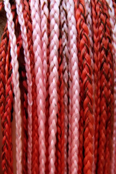 Kunstmatige kleurrijke gevlochten haar rood en roze — Stockfoto