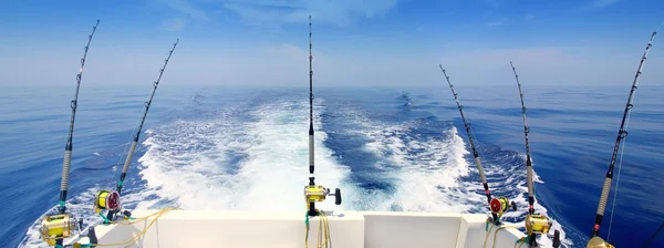 Barco pesca trolling haste panorâmica e bobinas mar azul Fotos De Bancos De Imagens