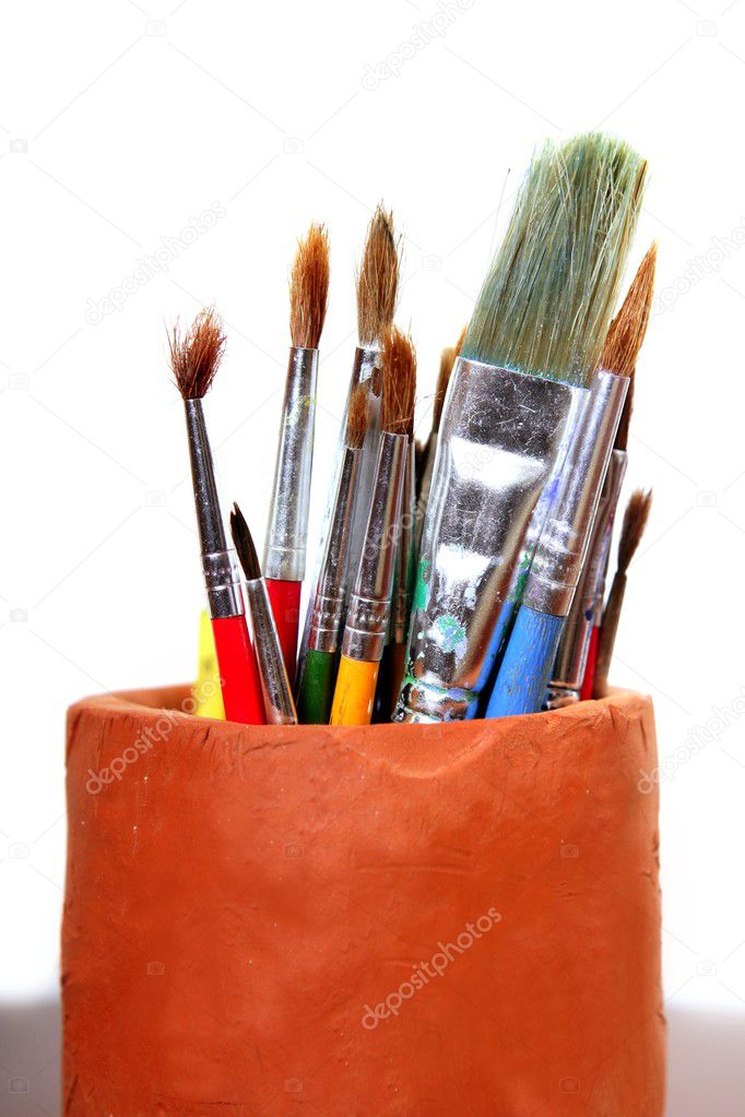 Artist brushes clay pot isolated on white