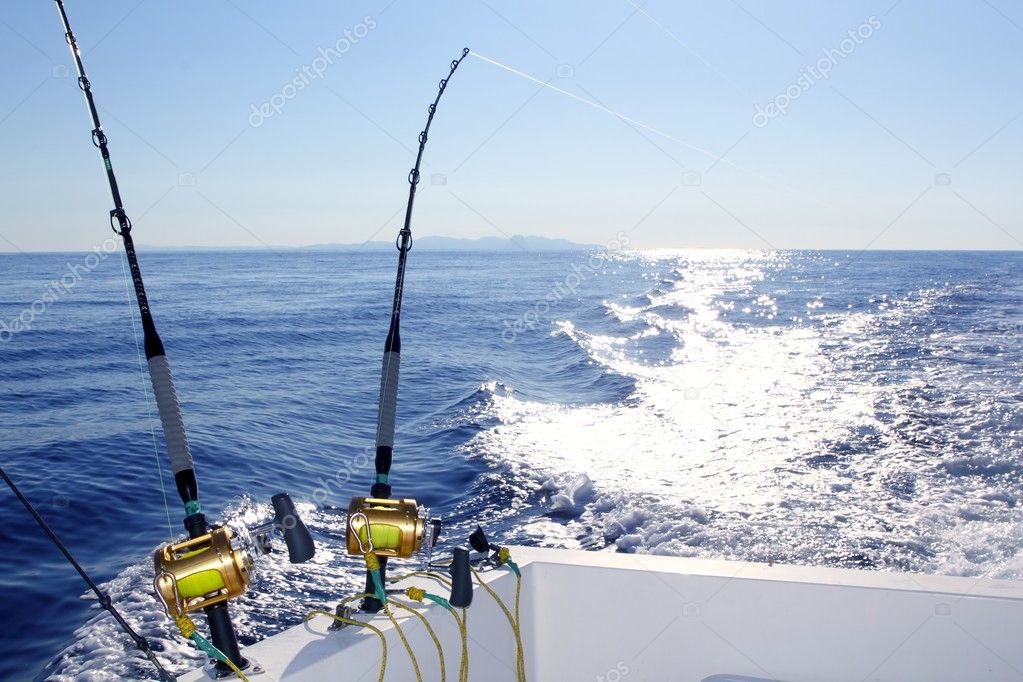 Trolling offshore fisherboat rod reels wake sea Stock Photo by