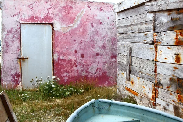 Красная стена, ветхая деревянная лодка — стоковое фото