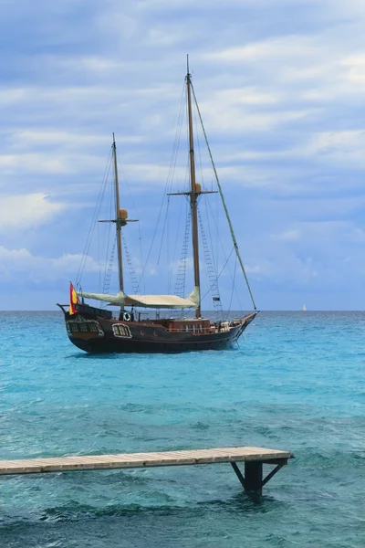 Pirates inspired wood sailboat anchored turquoise — Stock Photo, Image