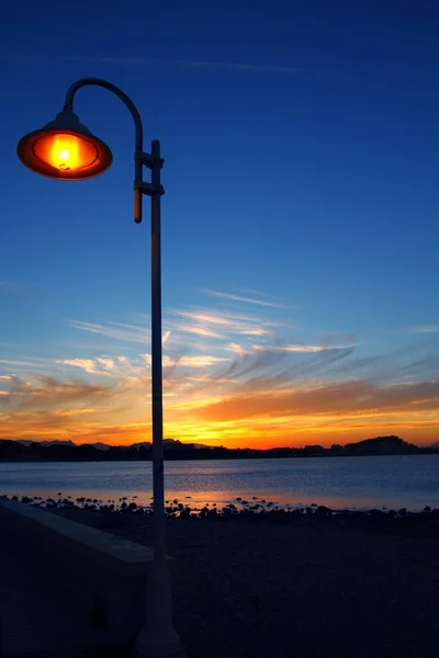 Naplemente, narancs, kék seascape könnyű lámpaoszlop — Stock Fotó