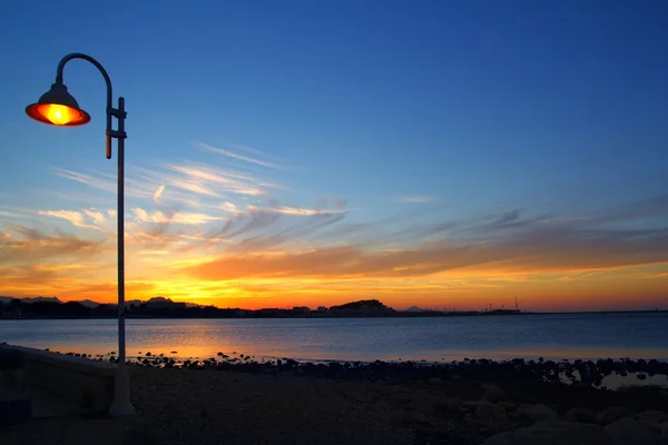 Sonnenuntergang orange blau Meereslandschaft Licht Laternenpfahl — Stockfoto