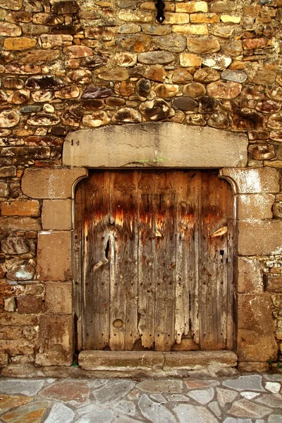 Porta de madeira envelhecida em alvenaria medieval Pirinéus — Fotografia de Stock