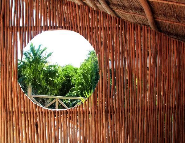 Circle window in wooden sticks cabin tropical Jungle — Stock Photo, Image