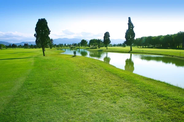 Golfpálya zöld fű mező tó tükrözi — Stock Fotó