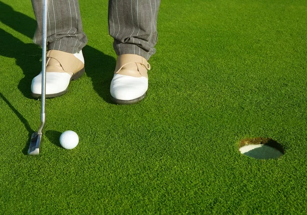 短いボールを置くゴルフ緑の穴コース男 — ストック写真