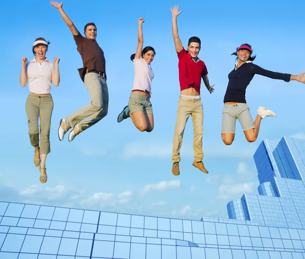 Jumping young group on city buildings — Stock Photo, Image