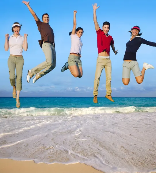 Jumping young happy group tropical beach — Stock Photo, Image
