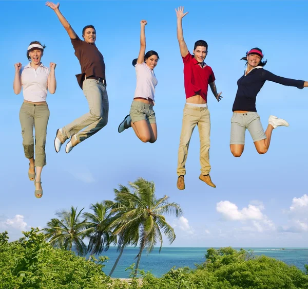 Jumping young happy group tropical beach — Stock Photo, Image