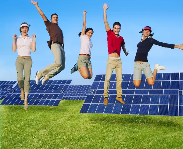 Saut jeune heureux groupe énergie solaire verte — Photo