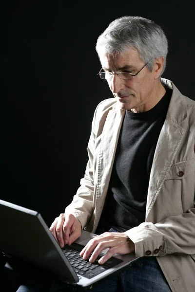 Бизнесмен, работающий на ноутбуке, седые волосы — стоковое фото