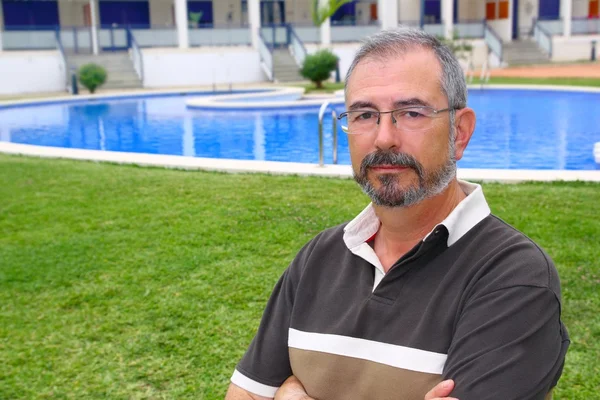 Sénior homem óculos relaxar na piscina jardim férias — Fotografia de Stock