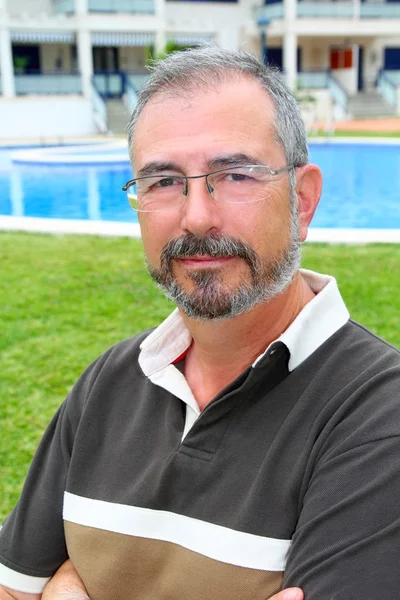 Sénior homem óculos relaxar na piscina jardim férias — Fotografia de Stock