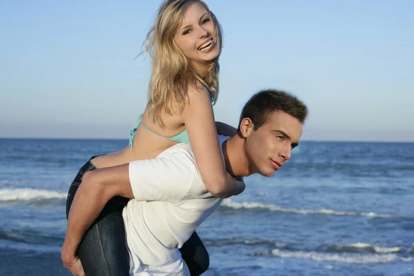Joven hermosa pareja jugando en la playa — Foto de Stock