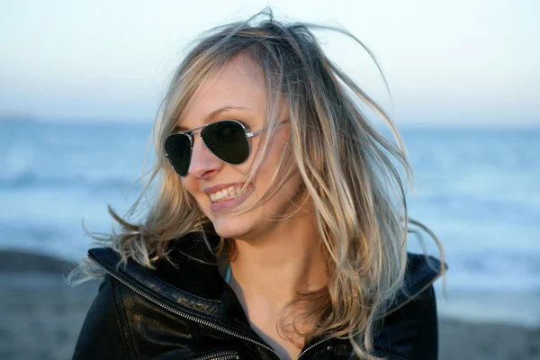 Blond meisje met zonnebril op het strand — Stockfoto