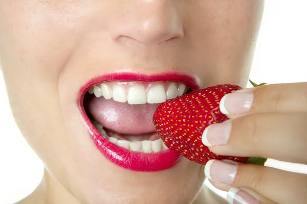 Schöne Frau isst eine rote Erdbeere — Stockfoto