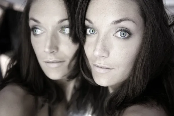 Mulher bonita no espelho como um retrato de gêmeos — Fotografia de Stock