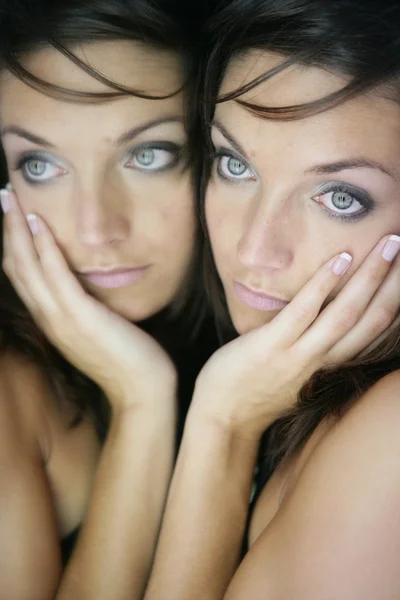 Beautiful woman on the mirror as a twins portrait — Stock Photo, Image