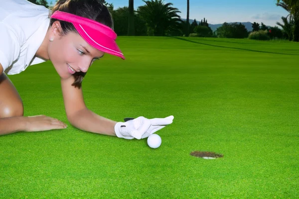 Golf buco verde donna umorismo sfarfallando mano una palla — Foto Stock