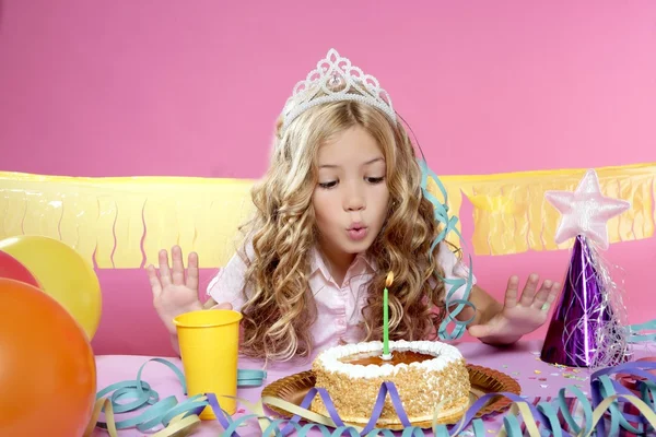 幸せのブロンドの女の子が誕生日パーティーでケーキのろうそくを吹き — ストック写真