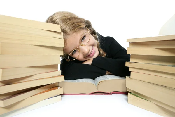 Pequeña estudiante rubia trenzada chica sonriendo con libros apilados —  Fotos de Stock