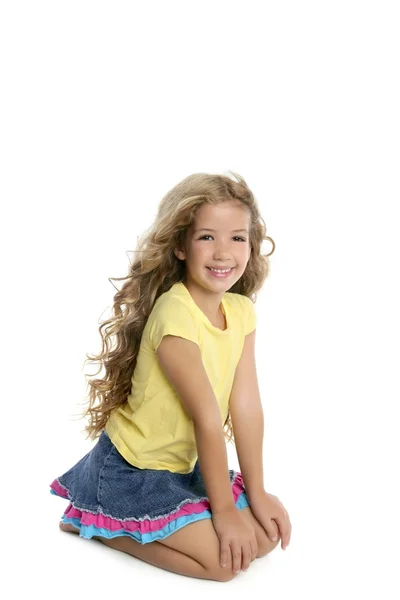 Blond meisje portret op haar knieën geïsoleerd op whit glimlachen — Stockfoto