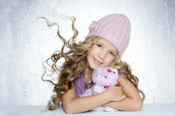 Téli divat sapka, kis lány ölelés mackó mosolyogva — Stock Fotó